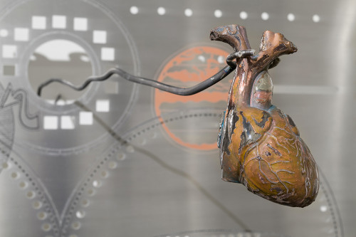 
     <i>Heart (copper)</i>, 
     2018<br />
     copper, resin, 
      8.5 x 11 x 17.5 cm<br />
     aluminium work in the background in cooperation with Genghis Khan Fabrication Co.