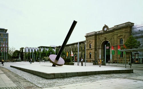 
     <i>Erdachse M. 1:1000000</i>, 
     1997<br />
     granite, 
      1765 x 1051 cm (stage), 1271 cm length (pillar), 30 x Ø 250 cm (plate)<br />
     Installation view station square Magdeburg, Germany, 1997
